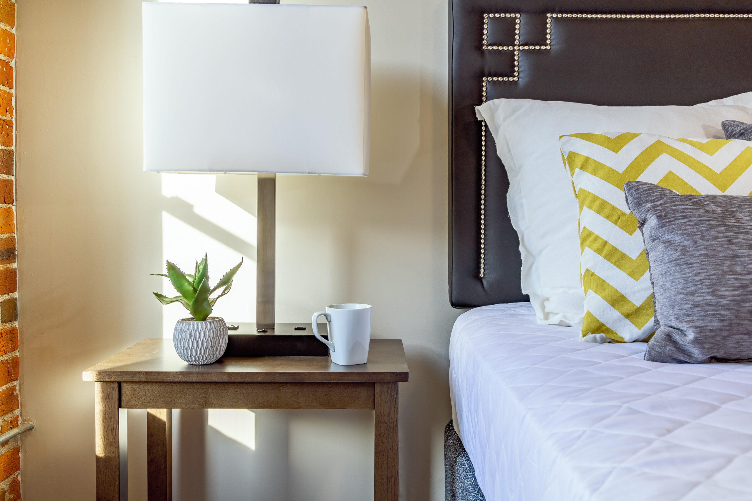 Nightstand and bed at Riverfront Park Travel Apartments